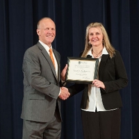 Doctor Potteiger posing for a photo with an award recipient in a black blazer